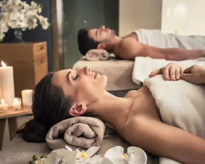 Young man and woman lying down on massage beds at Asian luxury spa and wellness center