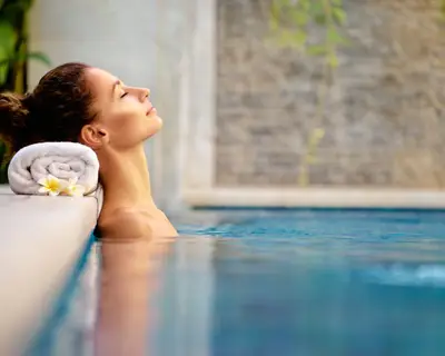 Beauty and body care. Sensual young woman relaxing in outdoor spa swimming pool.