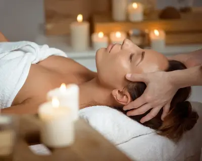 Young beautiful brunette girl having face massage relaxing in spa salon. Eyes closed. Copy space.