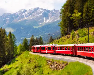 Red train moving in beautiful mountain landscape, Switzerland